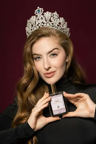 Modelo com coroa apresentando um perfume Zyone