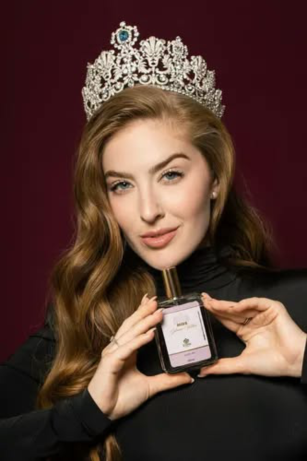 Modelo com coroa apresentando um perfume Zyone